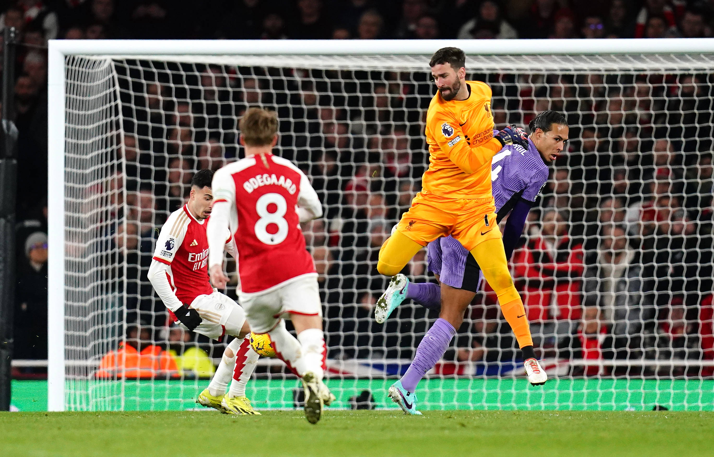 Liverpool goalkeeper Alisson Becker pictured colliding with teammate Virgil van Dijk (right) moments before Gabriel Martinelli (left) scored Arsenal's second goal in a 3-1 win in February 2024